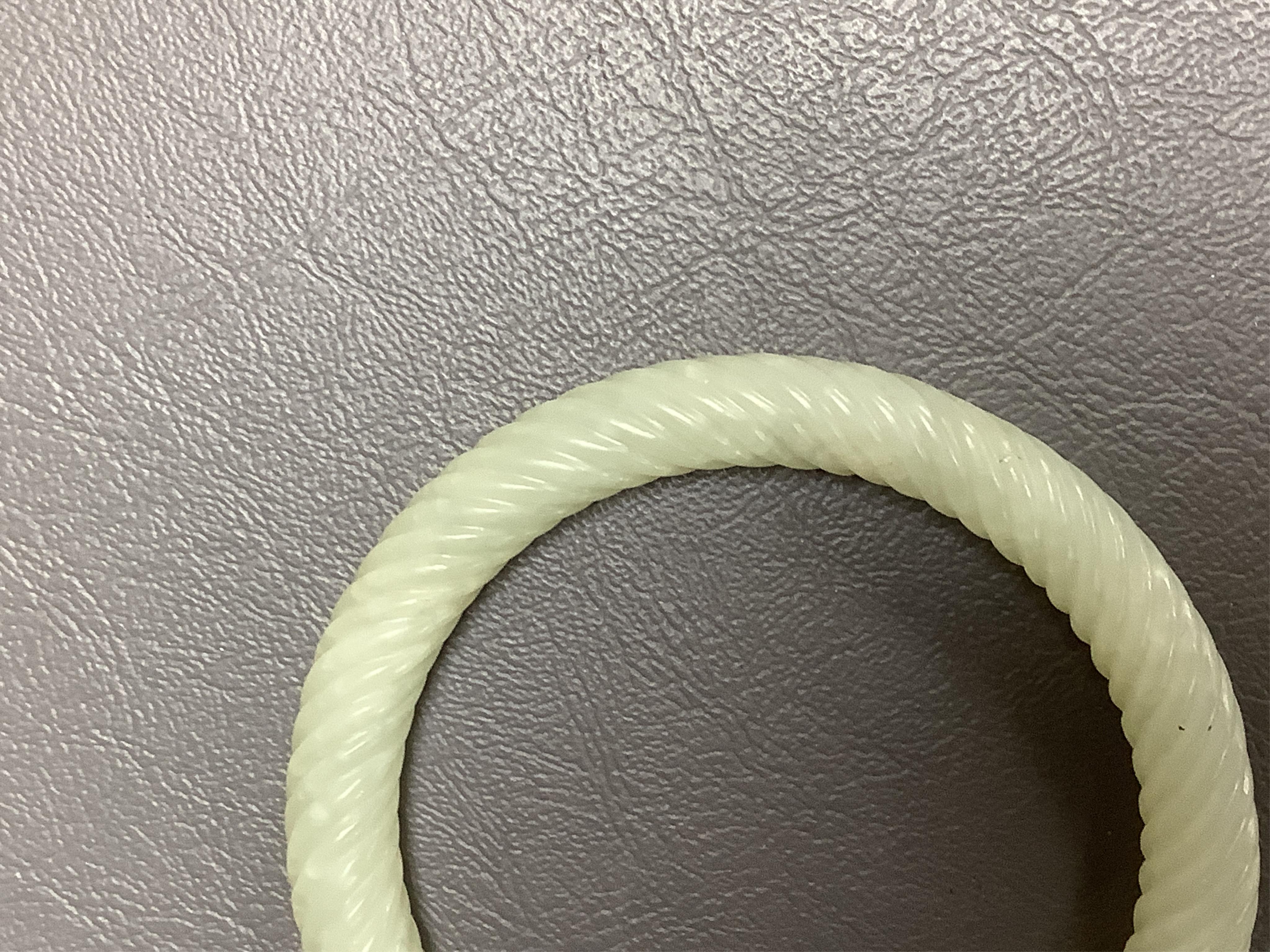 A Chinese pale celadon jade rope twist carved bangle, 8cm diameter